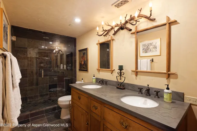 a bathroom with a granite countertop sink toilet a mirror a vanity and shower