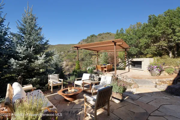 a view of a patio with table and chairs under an umbrella
