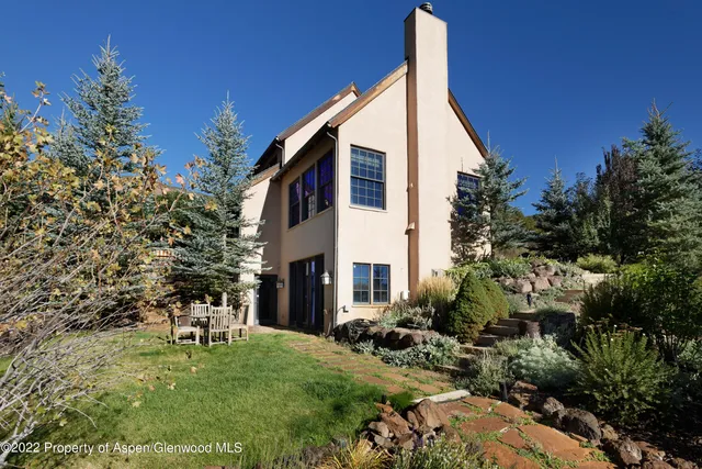 a backyard of a house with table and chairs