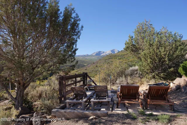 a view of a patio with table and chairs with wooden fence and plants