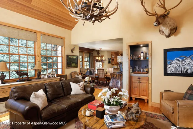 a living room with furniture a chandelier and a floor to ceiling window
