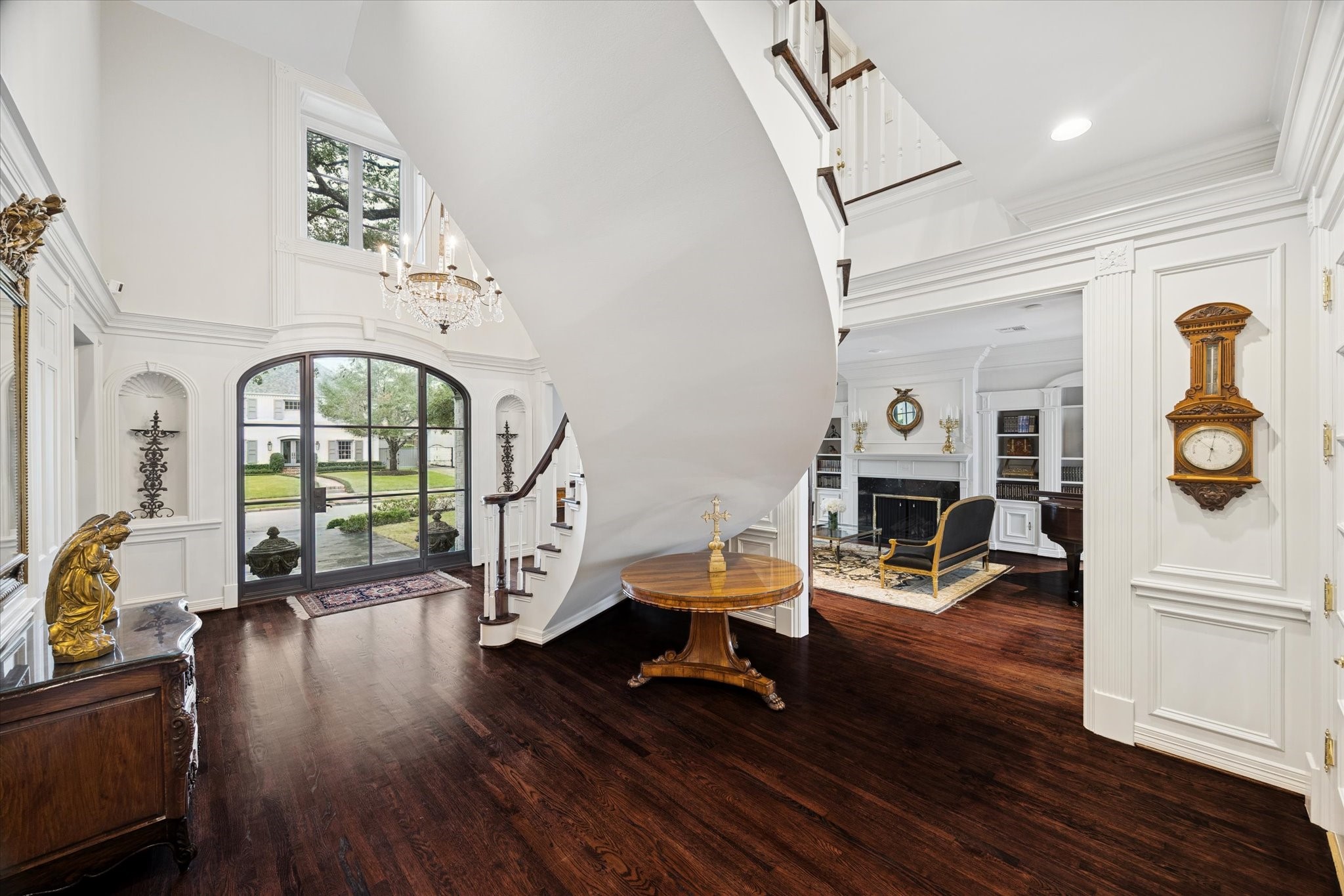 2249 Pelham Drive Houston, TX 77019 - Photo 12 of 50 Dramatic two-story foyer with curved staircase, arched windows, and grand entry doors, creating a breathtaking first impression and seamless flow into the formal living spaces.