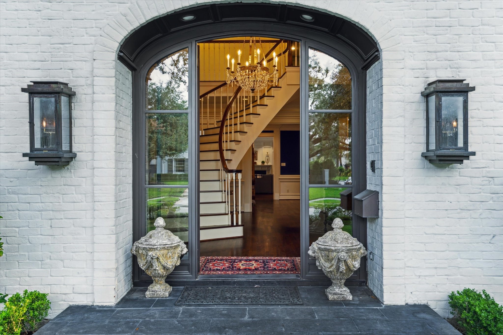 2249 Pelham Drive Houston, TX 77019 - Photo 2 of 50 A grand entry welcomes guests with soaring ceilings, intricate millwork, and a sweeping staircase beneath a sparkling chandelier.