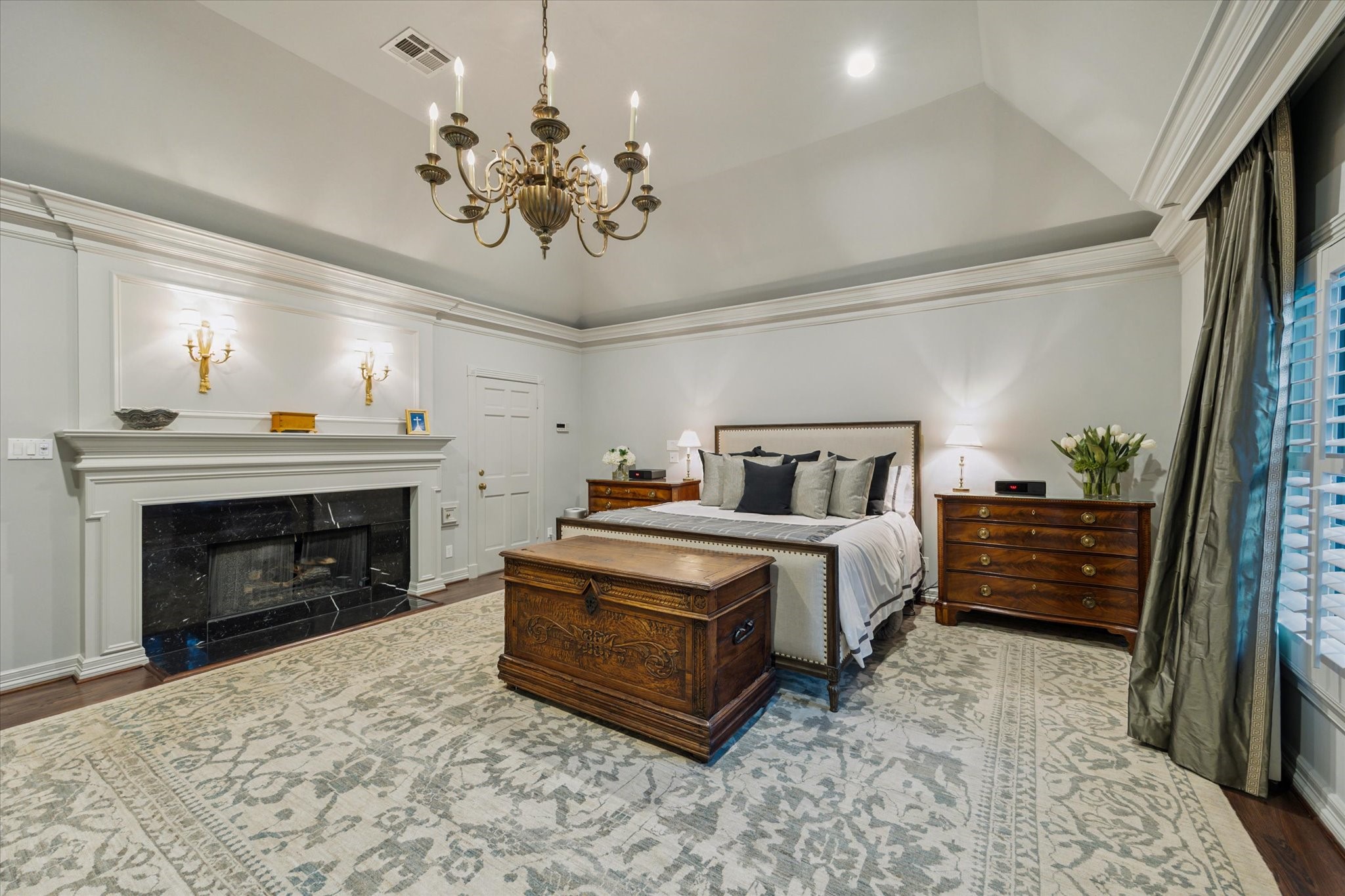 2249 Pelham Drive Houston, TX 77019 - Photo 31 of 50 Spacious primary bedroom with vaulted ceiling, chandelier, and fireplace.