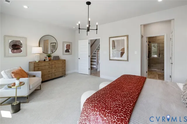 a spacious bedroom with a bed a dresser and a large window