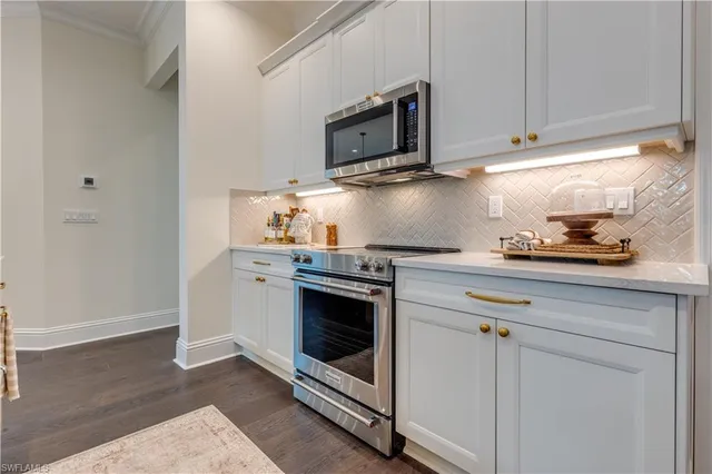 a kitchen with stainless steel appliances granite countertop a stove microwave and sink