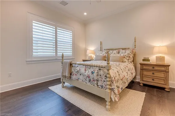a bed sitting in a bedroom next to a window and dresser