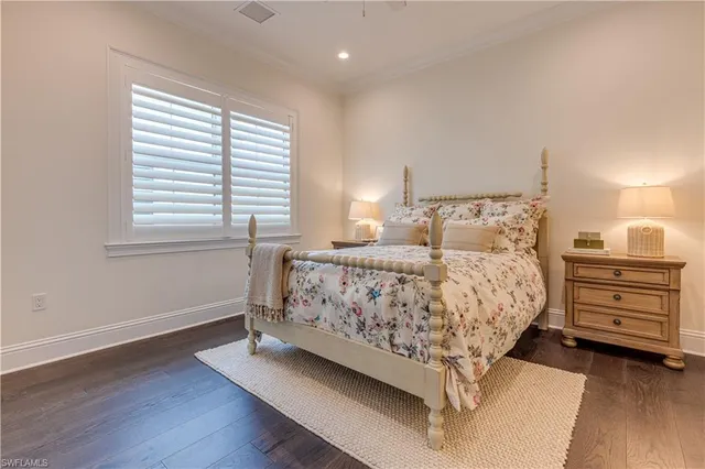 a bed sitting in a bedroom next to a window and dresser