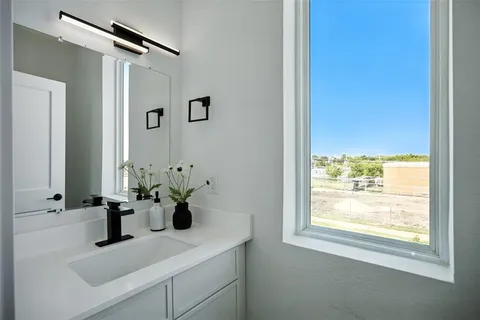 a bathroom with a sink a mirror and a window