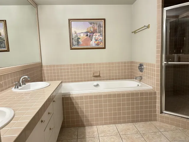 a bathroom with a tub a sink and glass door