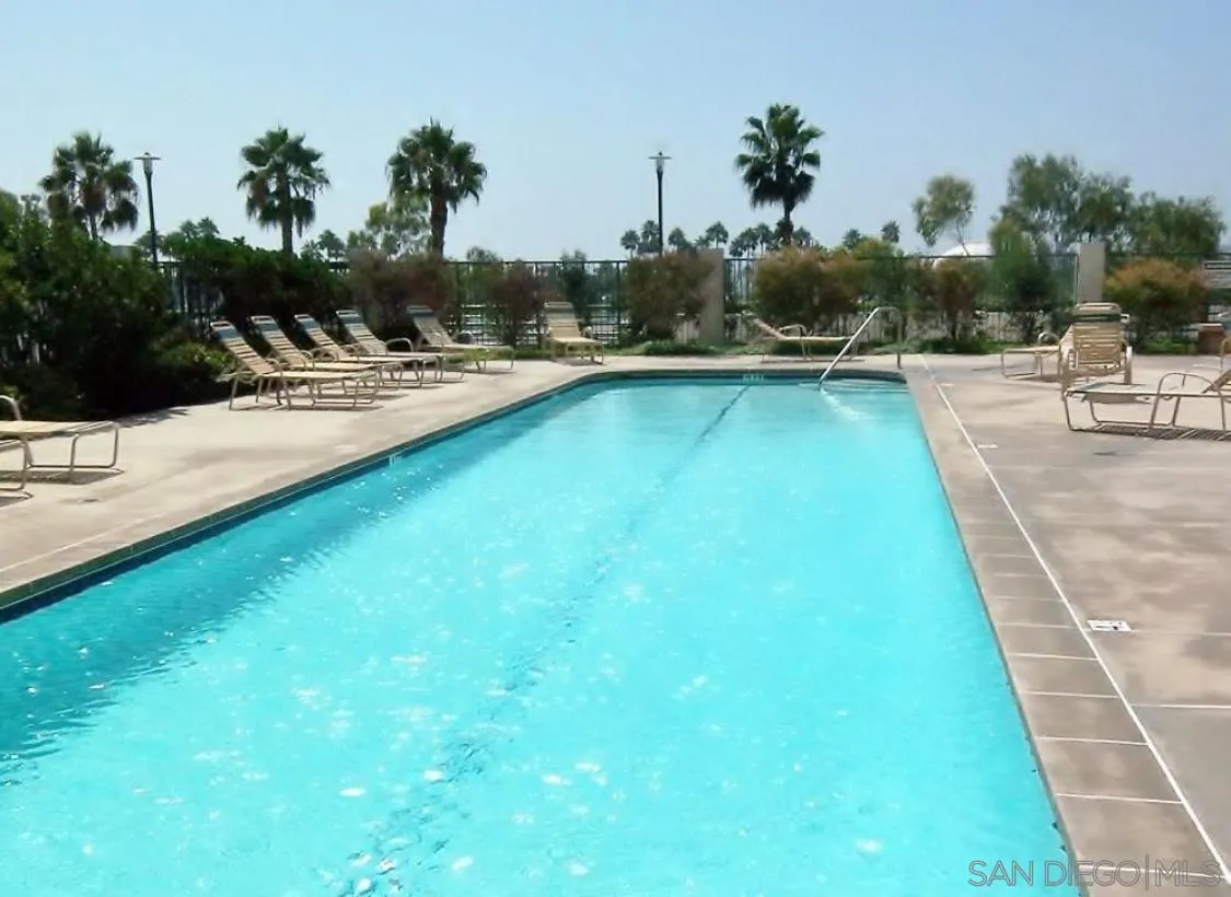 525 East Seaside Way, Unit 1607 Long Beach, CA 90802 - Photo 29 of 41 a view of a swimming pool with a bench and trees in the background