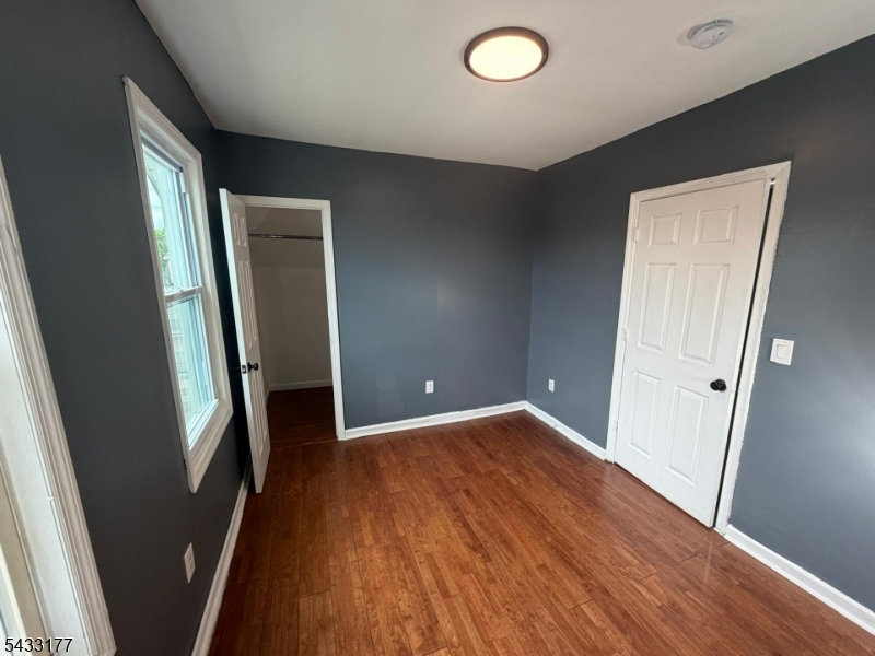 166 Renner Avenue, Unit 3 Newark, NJ 07112 - Photo 18 of 24 an empty room with wooden floor and a bathroom