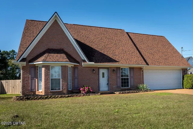 a view of a house with yard and garage