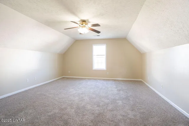 an empty room with windows and chandelier fan
