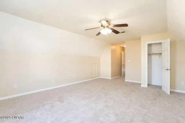 an empty room with closet and windows