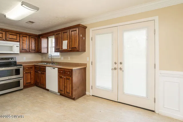 a kitchen with stainless steel appliances granite countertop a stove a sink and a refrigerator