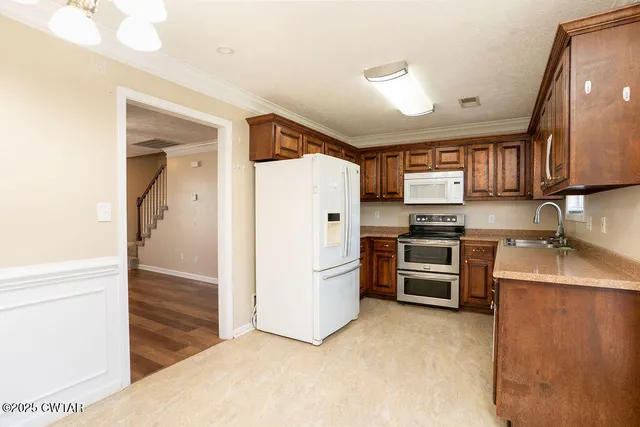 a kitchen with granite countertop a refrigerator and a sink