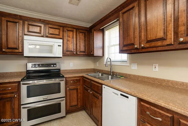 a kitchen with granite countertop cabinets stainless steel appliances and a window