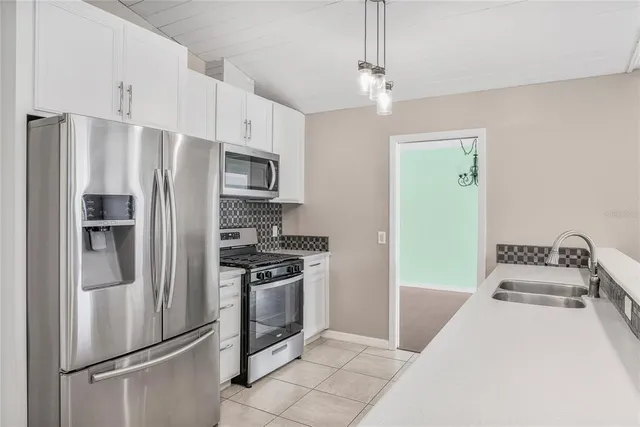 a kitchen with white cabinets and stainless steel appliances