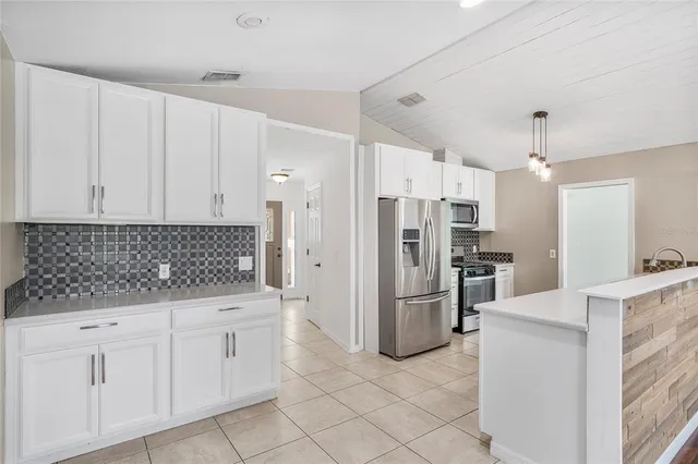 a large kitchen with a stove and a refrigerator