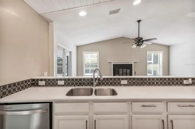 a view of kitchen with granite countertop cabinets and refrigerator