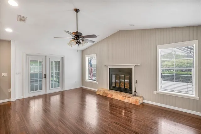 a view of a livingroom with wooden floor and a ceiling fan