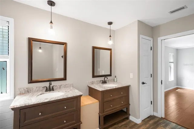 a bathroom with a double vanity sink mirror and shower