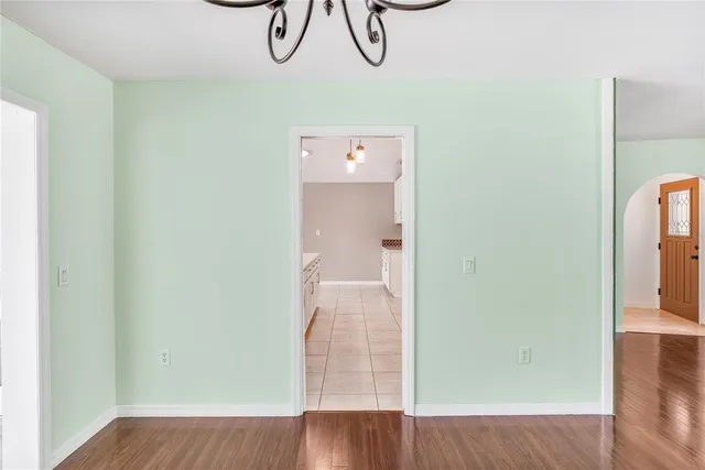 a view of a room with wooden floor and chandelier