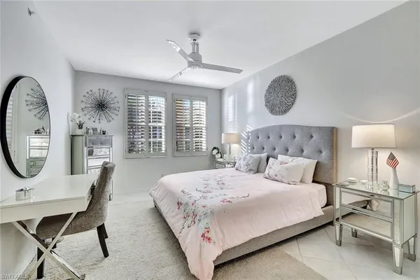 a bedroom with a bed a window and a chandelier