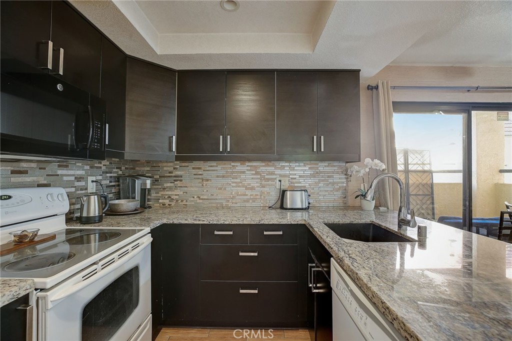 23 Pearl Laguna Niguel, CA 92677 - Photo 12 of 37 a kitchen with granite countertop a sink a stove and cabinets