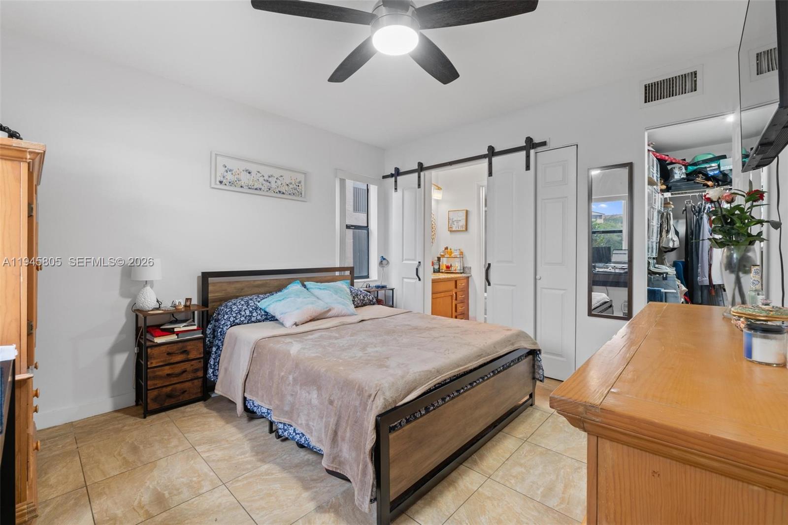 10005 Winding Lake Road, Unit 106 Sunrise, FL 33351 - Photo 14 of 41 a bedroom with a bed and a chandelier