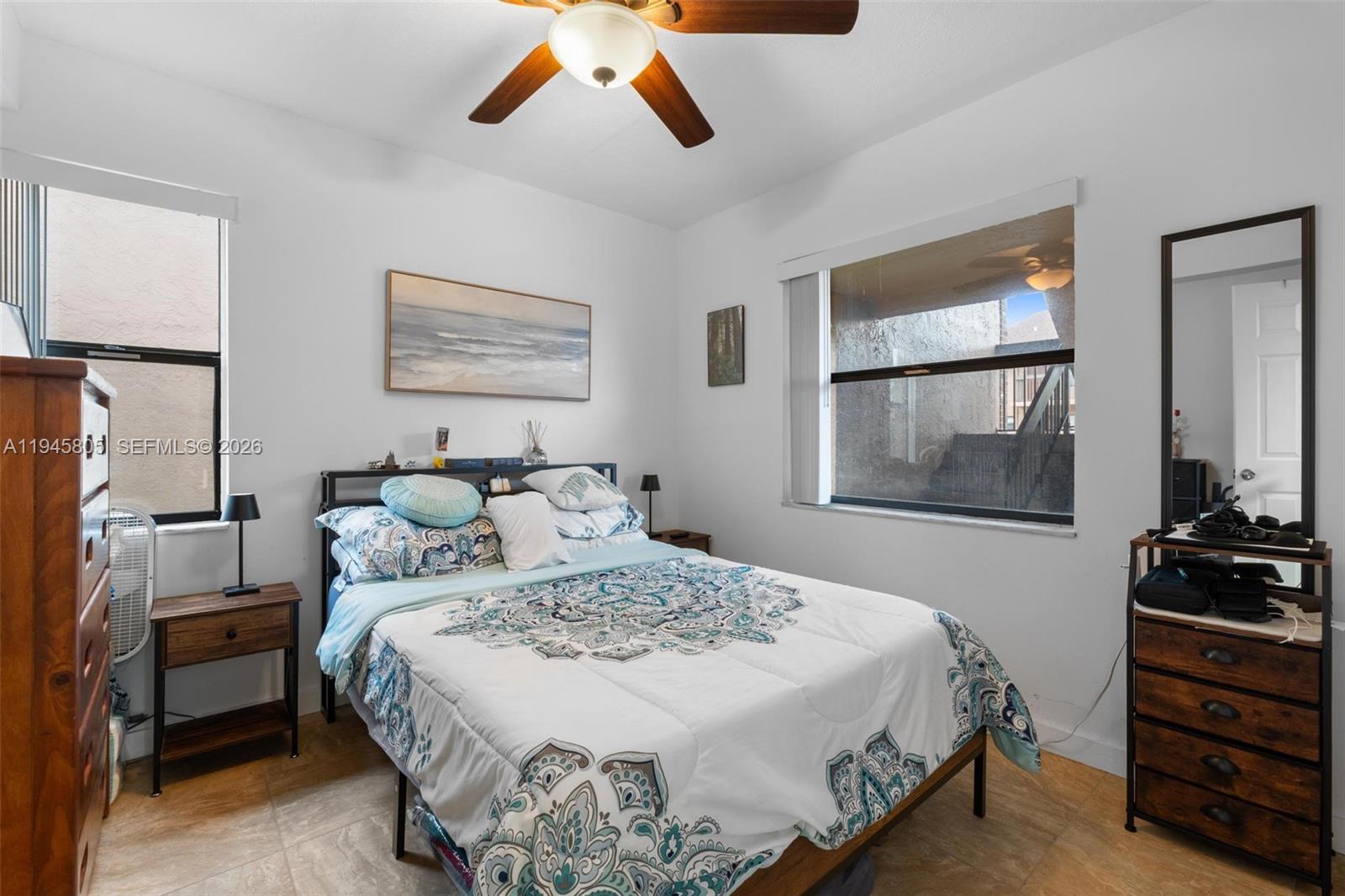 10005 Winding Lake Road, Unit 106 Sunrise, FL 33351 - Photo 21 of 41 a bedroom with a bed and dresser with mirror