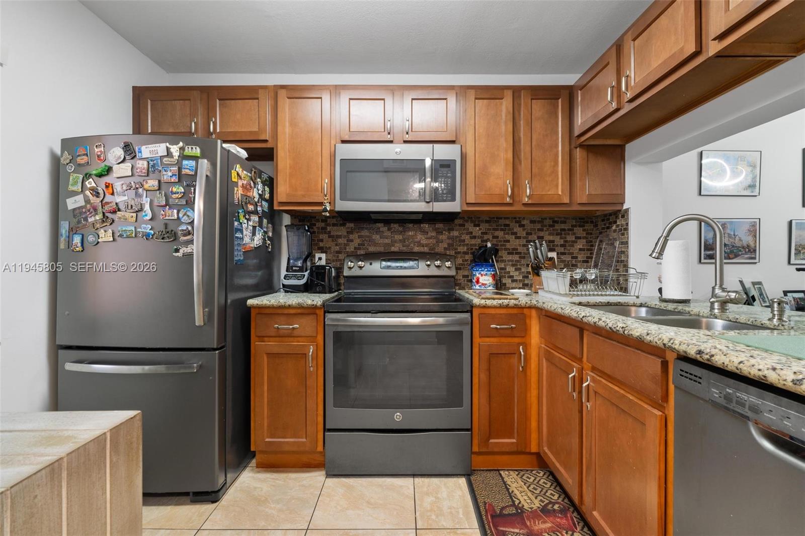 10005 Winding Lake Road, Unit 106 Sunrise, FL 33351 - Photo 5 of 41 a kitchen with stainless steel appliances granite countertop a refrigerator and a sink