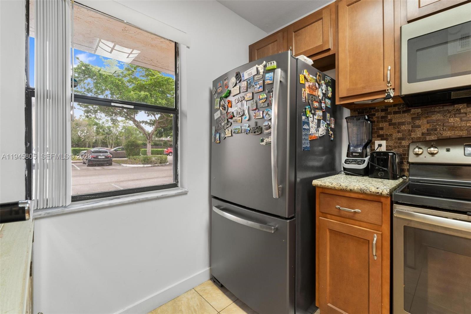 10005 Winding Lake Road, Unit 106 Sunrise, FL 33351 - Photo 7 of 41 a kitchen with a refrigerator and a stove