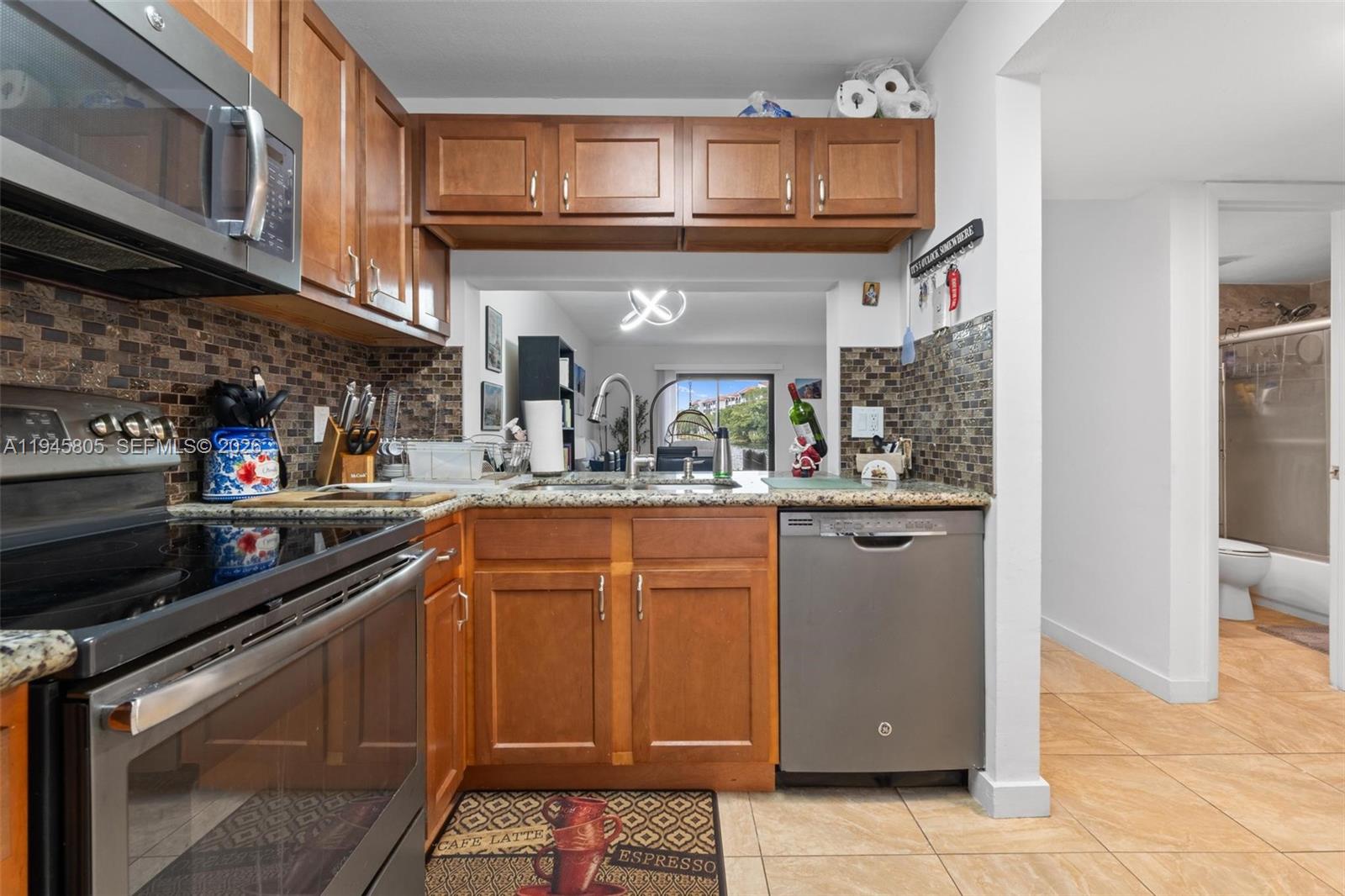 10005 Winding Lake Road, Unit 106 Sunrise, FL 33351 - Photo 8 of 41 a kitchen with stainless steel appliances granite countertop a refrigerator a sink and dishwasher