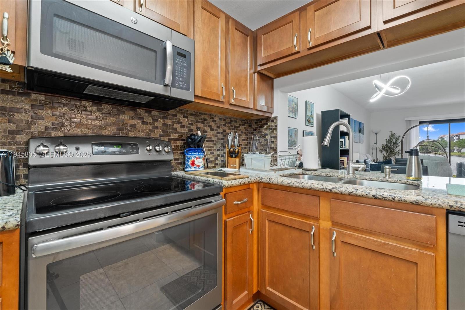 10005 Winding Lake Road, Unit 106 Sunrise, FL 33351 - Photo 9 of 41 a kitchen with granite countertop a stove microwave and sink
