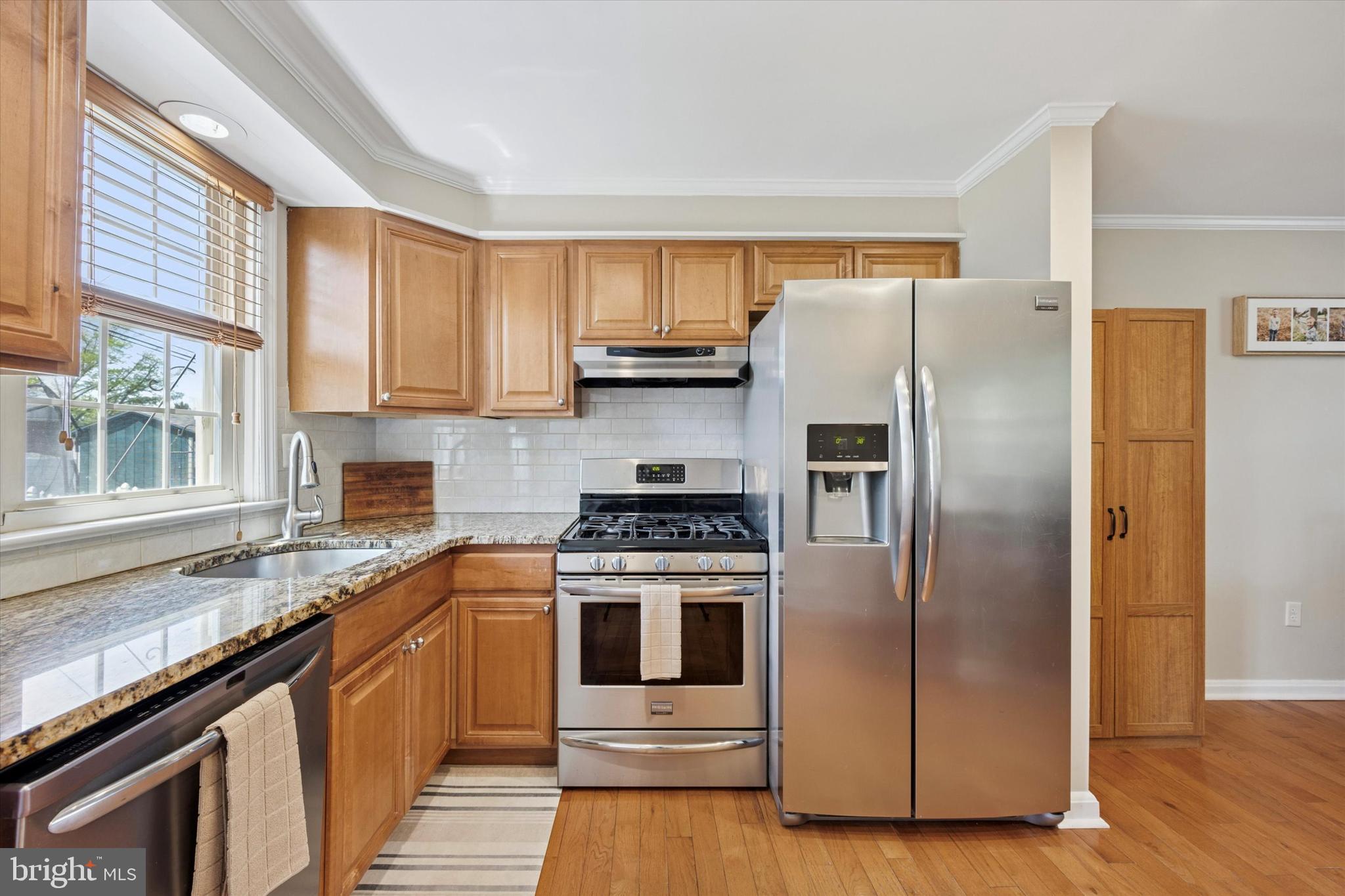 256 Ridgewood Road Springfield, PA 19064 - Photo 11 of 32 a kitchen with a stove a sink and a refrigerator