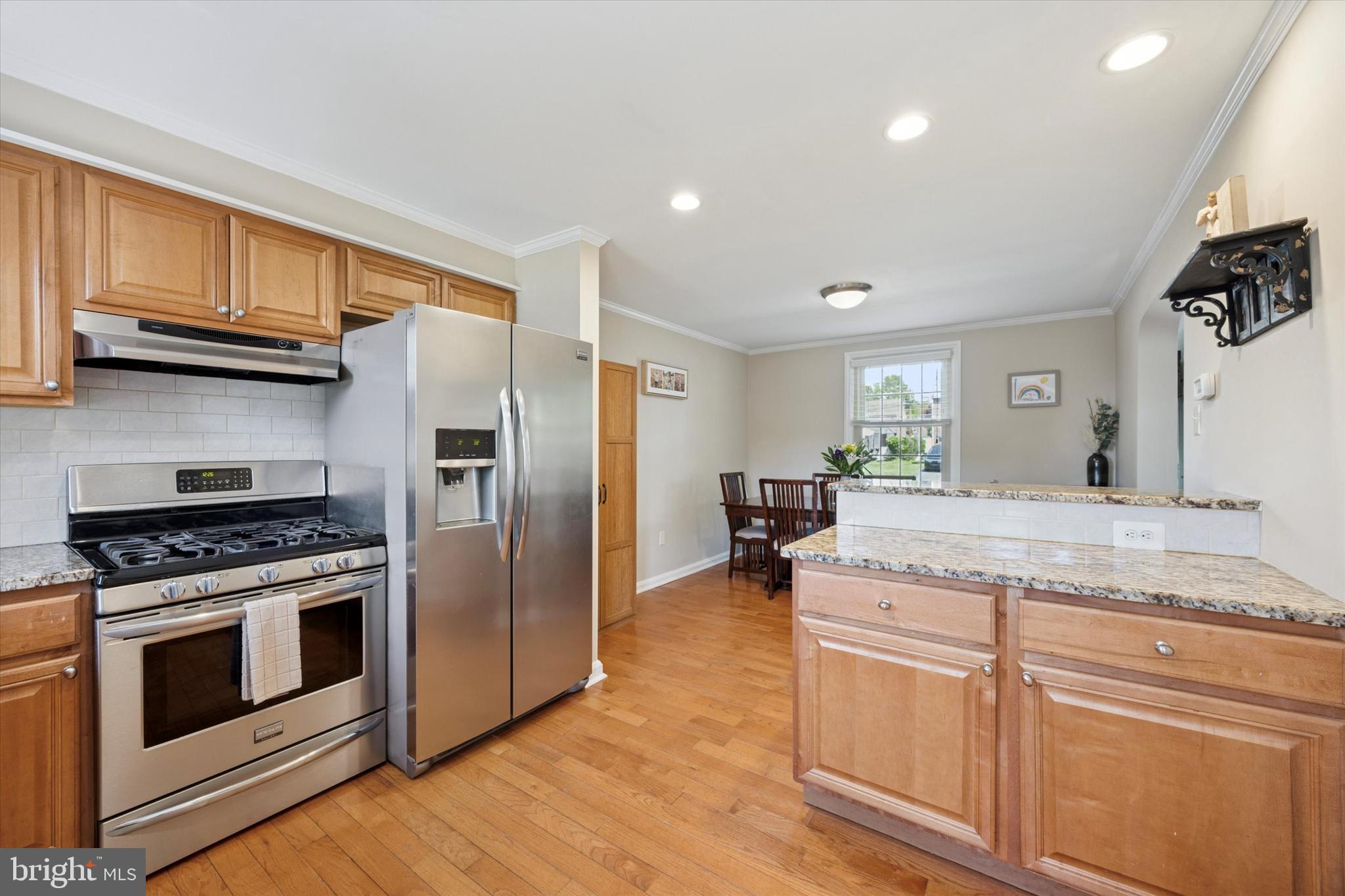 256 Ridgewood Road Springfield, PA 19064 - Photo 12 of 32 a kitchen with granite countertop a stove a sink and a refrigerator