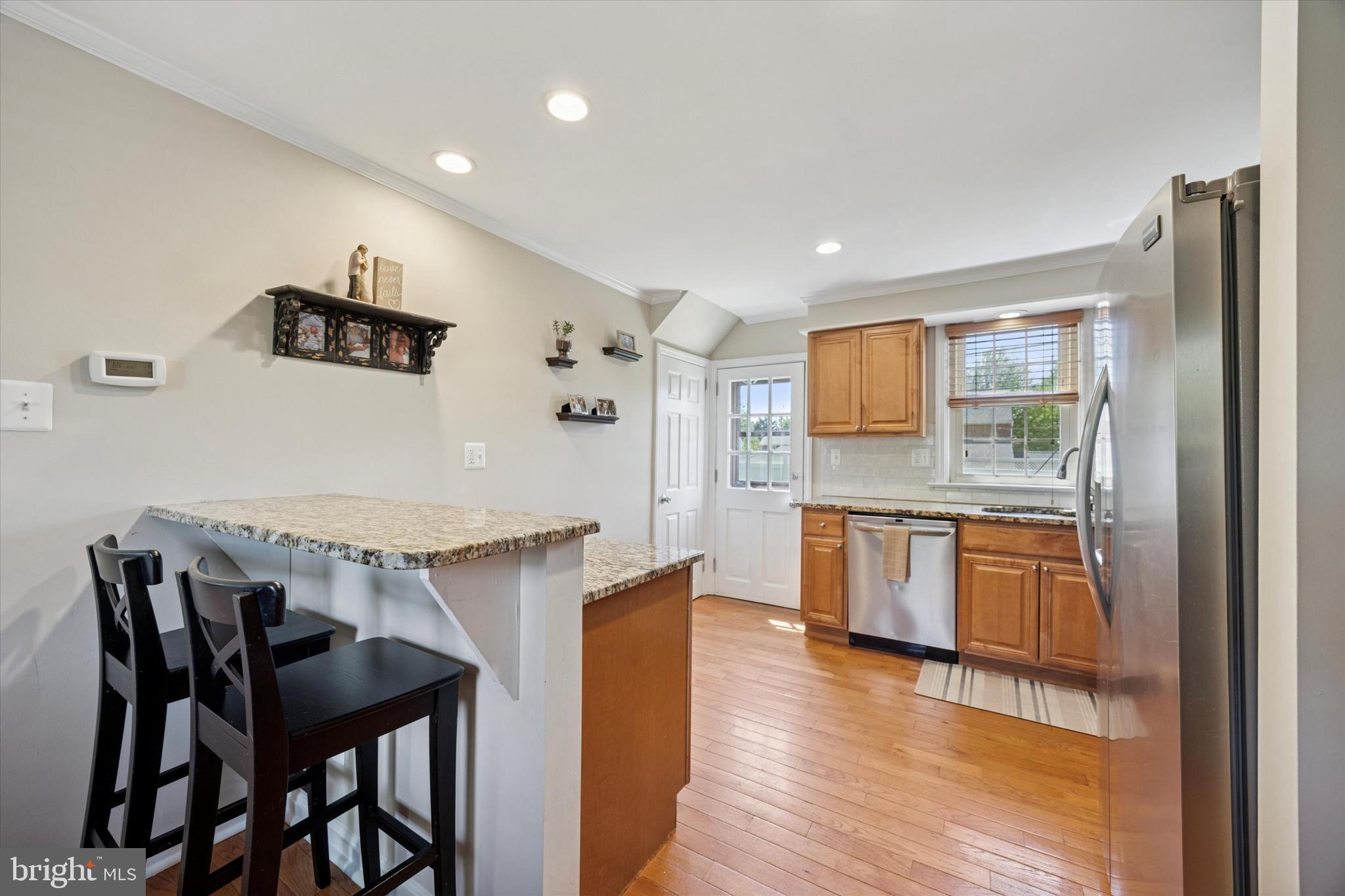 256 Ridgewood Road Springfield, PA 19064 - Photo 9 of 32 a kitchen with granite countertop a table chairs stove and refrigerator