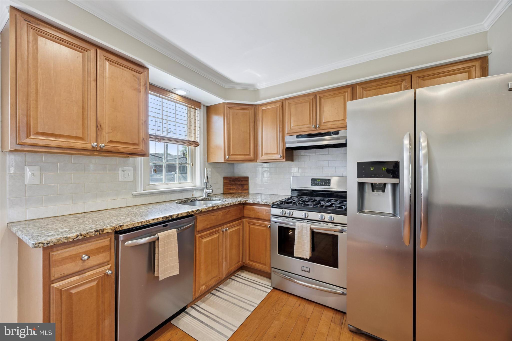 256 Ridgewood Road Springfield, PA 19064 - Photo 10 of 32 a kitchen with stainless steel appliances granite countertop a stove a sink and a refrigerator
