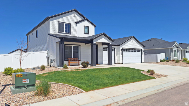 1127 4240 North Enoch, UT 84721 - Photo 6 of 56 View of front of property with concrete driveway, an attached garage, and a porch
