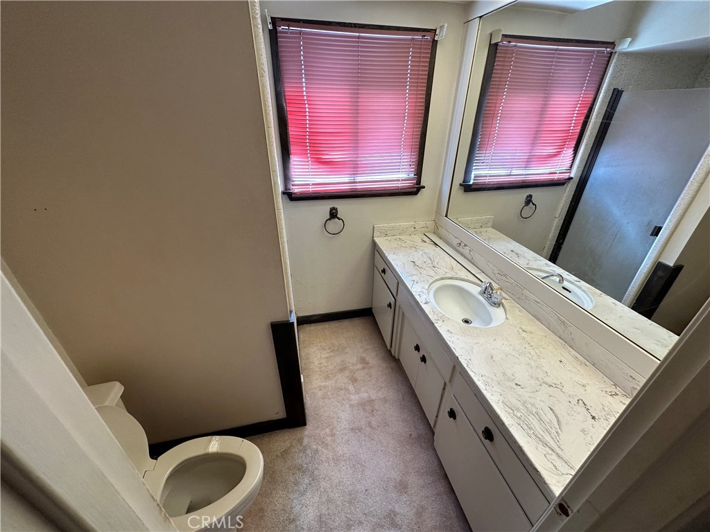 602 Elise Court Merced, CA 95340 - Photo 12 of 20 a bathroom with a granite countertop toilet sink and mirror