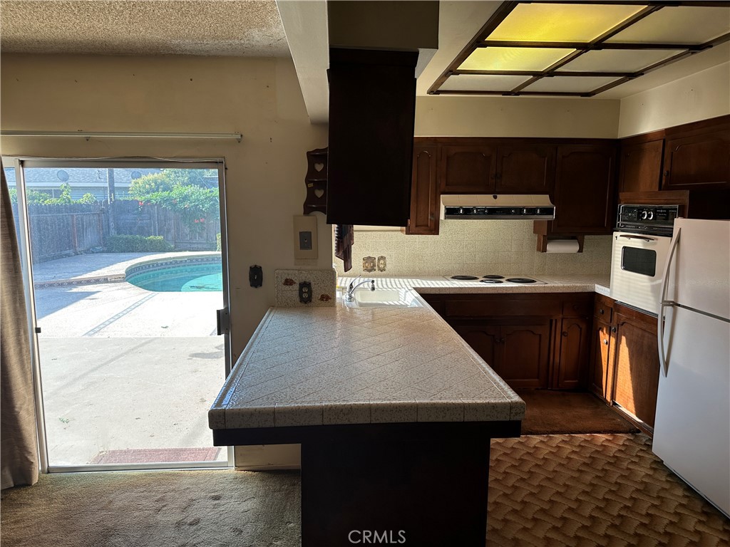 602 Elise Court Merced, CA 95340 - Photo 5 of 20 a kitchen with a sink a kitchen island a stove and a refrigerator
