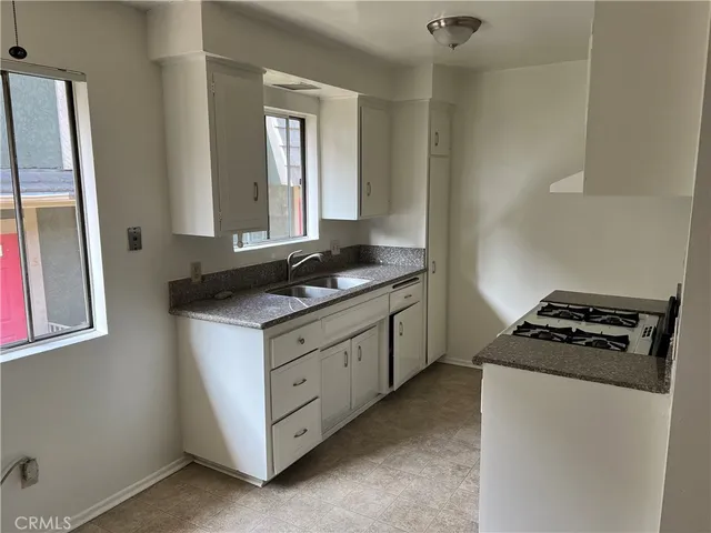a kitchen with granite countertop cabinets a stove and a refrigerator