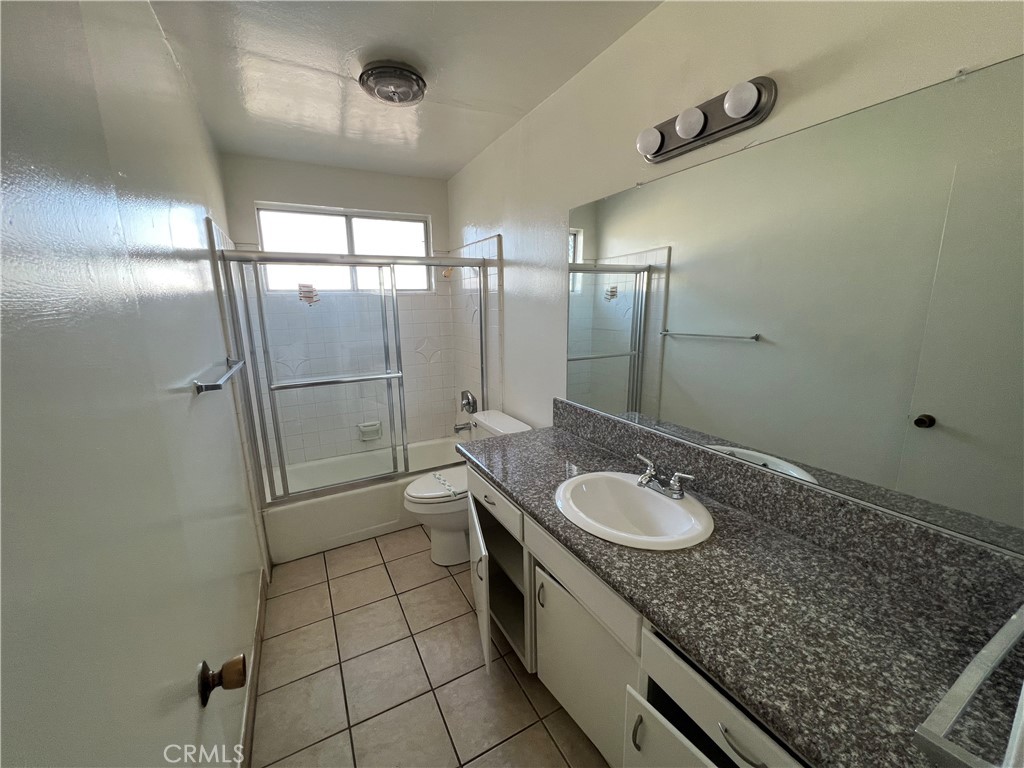 387 North Mentor Avenue, Unit 9 Pasadena, CA 91106 - Photo 6 of 9 a bathroom with a granite countertop sink a toilet and shower