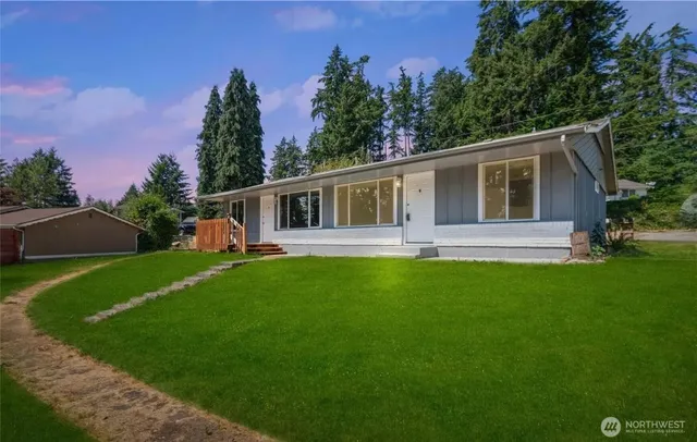 a front view of a house with yard and green space