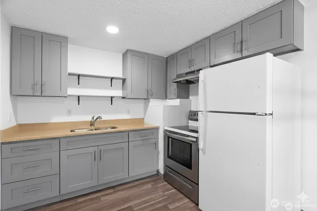 a kitchen with appliances a sink and cabinets