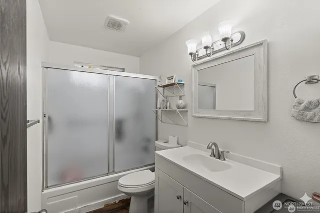 a bathroom with a sink toilet a mirror and shower