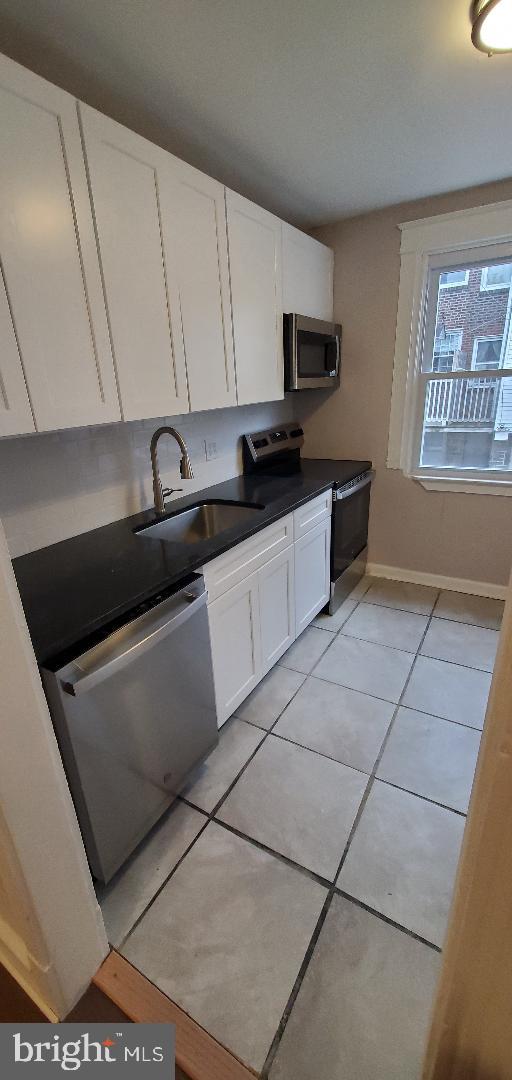 7220 Lamport Road Upper Darby, PA 19082 - Photo 6 of 14 a kitchen with stainless steel appliances a sink a stove a microwave a sink and cabinets