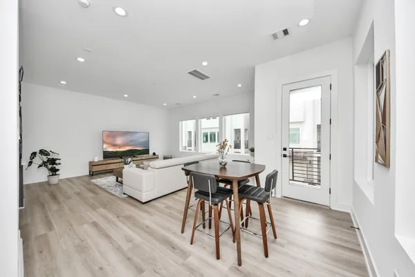 a living room with furniture a flat screen tv and a wooden floor